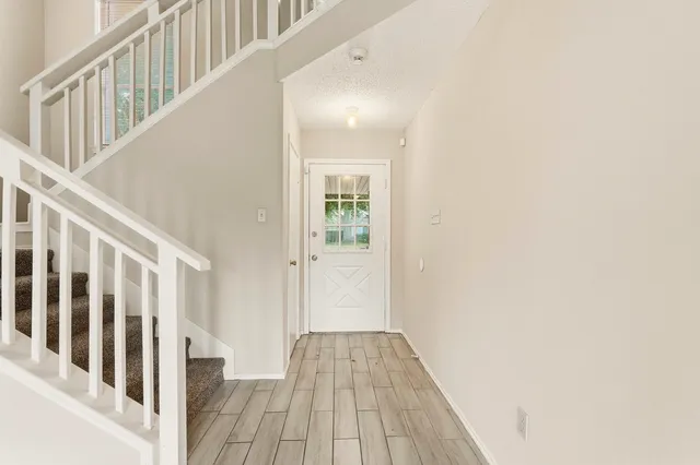 a view of a hallway with wooden floor and entryway