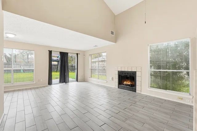 a view of an empty room with a fireplace and a large window