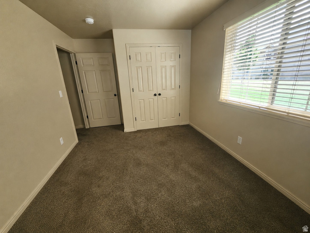 2525 West 450 South, Unit 8 Springville, UT 84663 - Photo 12 of 22 Carpeted room with neutral-toned walls, featuring a window with horizontal blinds and a built-in closet with bifold doors