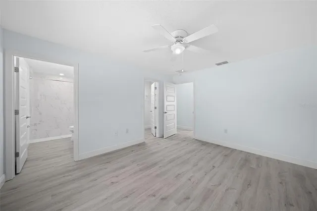 an empty room with wooden floor and door