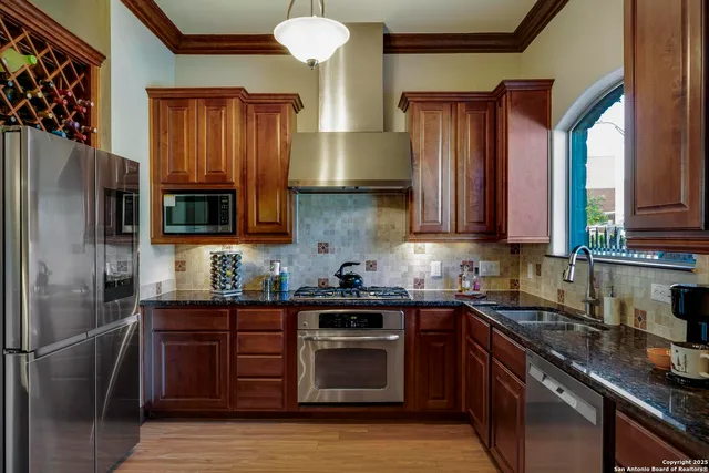 a kitchen with stainless steel appliances granite countertop a sink stove and refrigerator