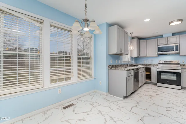 a kitchen with stainless steel appliances granite countertop a stove and a refrigerator