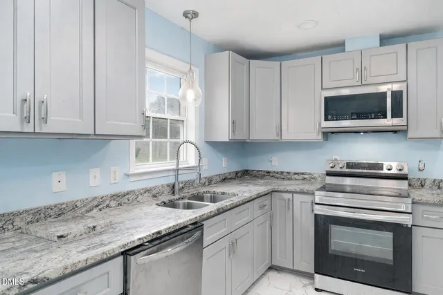 a bedroom with a bed a potted plant on dresser and a window