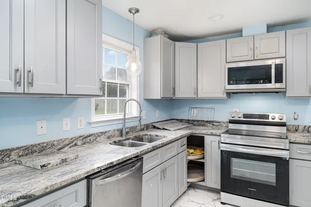 a kitchen with stainless steel appliances granite countertop a sink a stove a microwave and cabinets