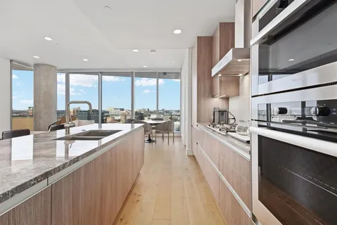 a large kitchen with stainless steel appliances lots of counter space and a sink