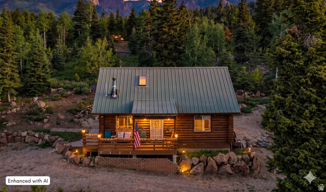 706 Tranquility Drive Springdale, UT 84767 - Photo 1 of 55 Twilight Mountain Retreat: A stunning evening view highlighting the warm, inviting glow of this secluded log home.