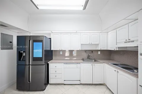 a kitchen with white cabinets and stainless steel appliances