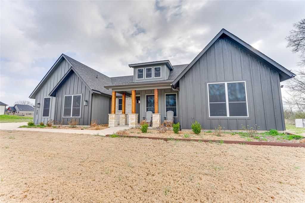 a front view of a house with a yard and seating space