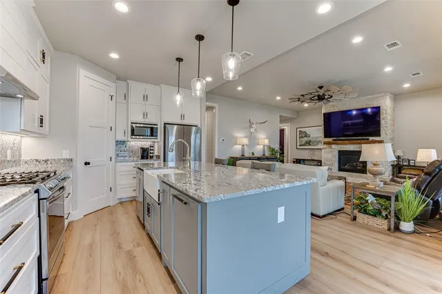 a kitchen with stainless steel appliances granite countertop a stove oven and a refrigerator