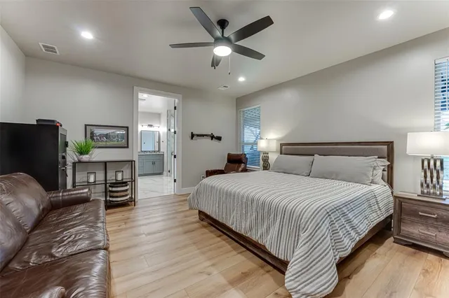 a bedroom with a bed a couch and a chandelier