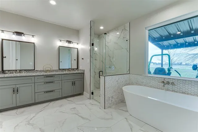 a spacious bathroom with a granite countertop sink a toilet a mirror and shower