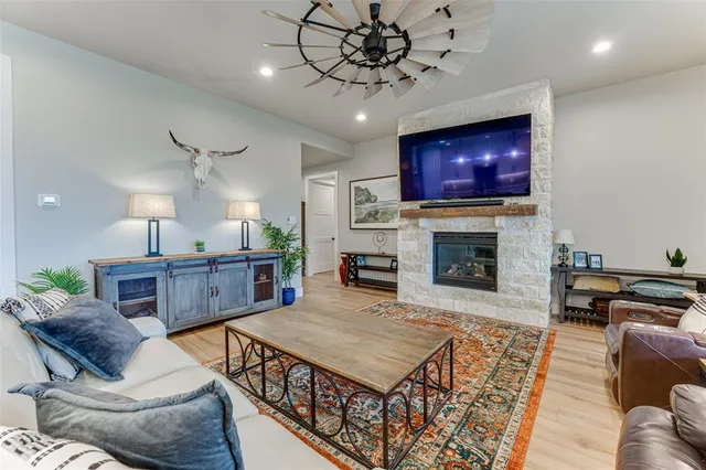 a living room with furniture a flat screen tv and a fireplace