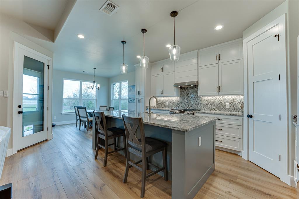 3167 County Road 1076 Celeste, TX 75423 - Photo 9 of 26 a kitchen with kitchen island granite countertop a sink cabinets and wooden floor
