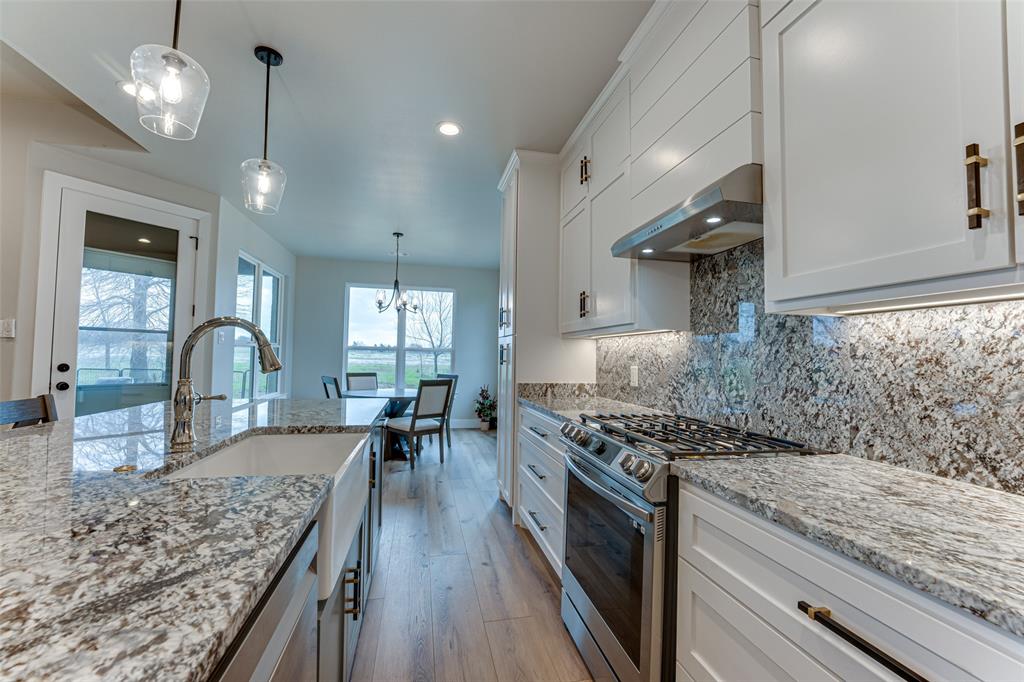 3167 County Road 1076 Celeste, TX 75423 - Photo 10 of 26 a kitchen with stainless steel appliances granite countertop a lot of counter space and wooden floors