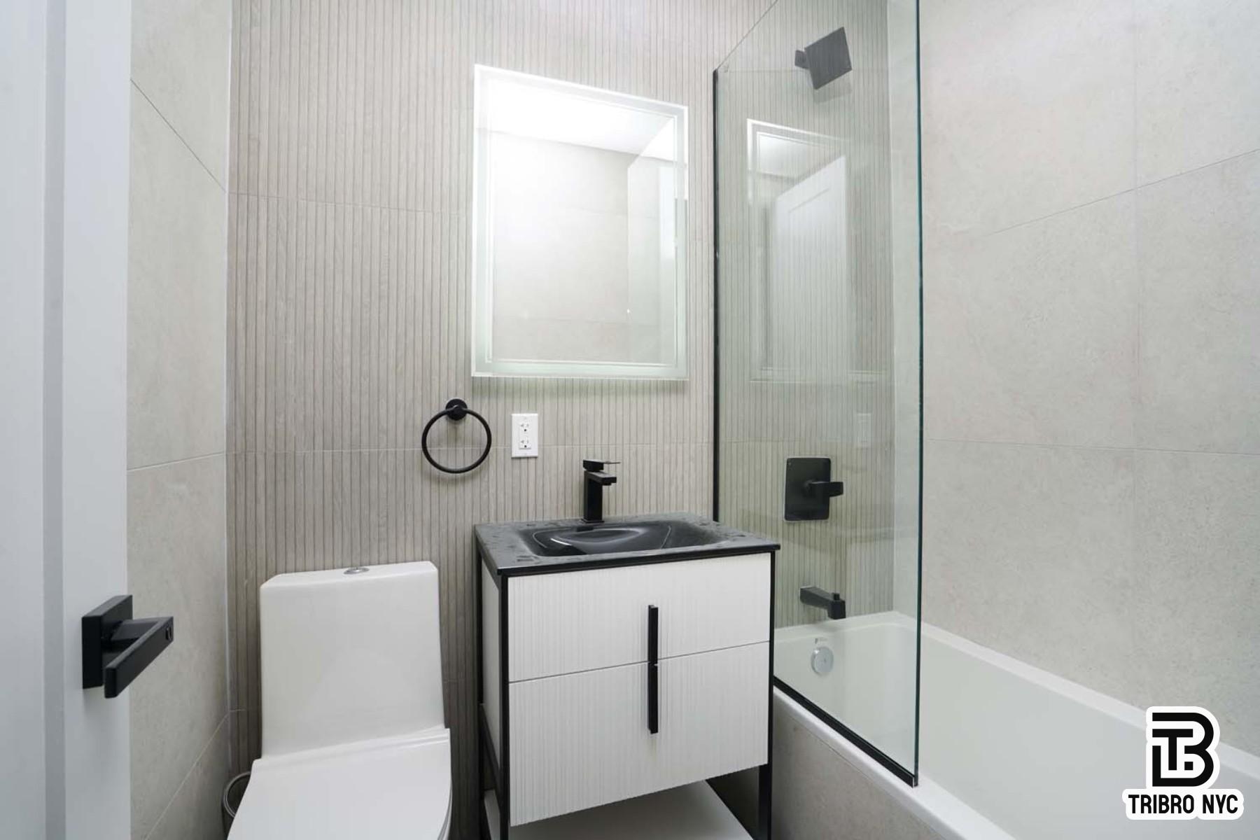 141 Meserole Street, Unit 4B Brooklyn, NY 11206 - Photo 9 of 9 a bathroom with a sink a toilet and shower