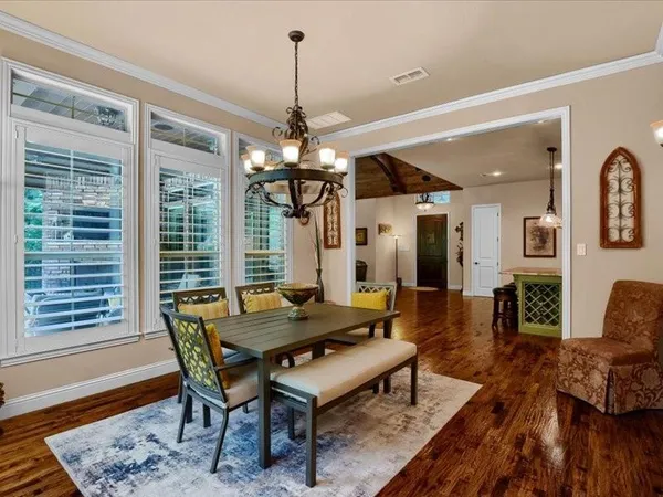 a dining room with furniture a chandelier and wooden floor