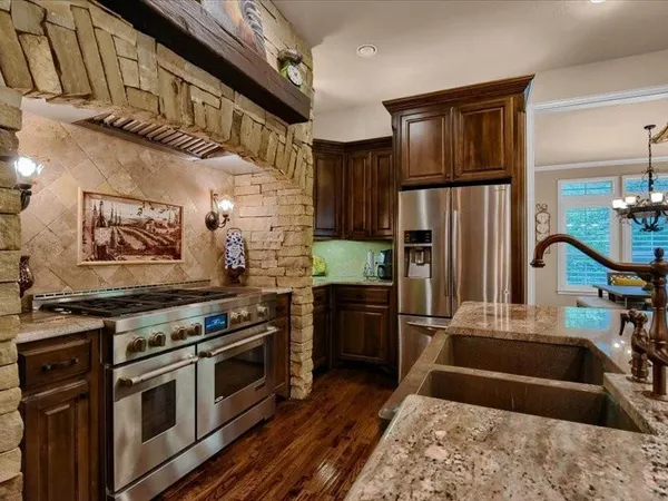 a kitchen with stainless steel appliances granite countertop a stove a refrigerator and a sink