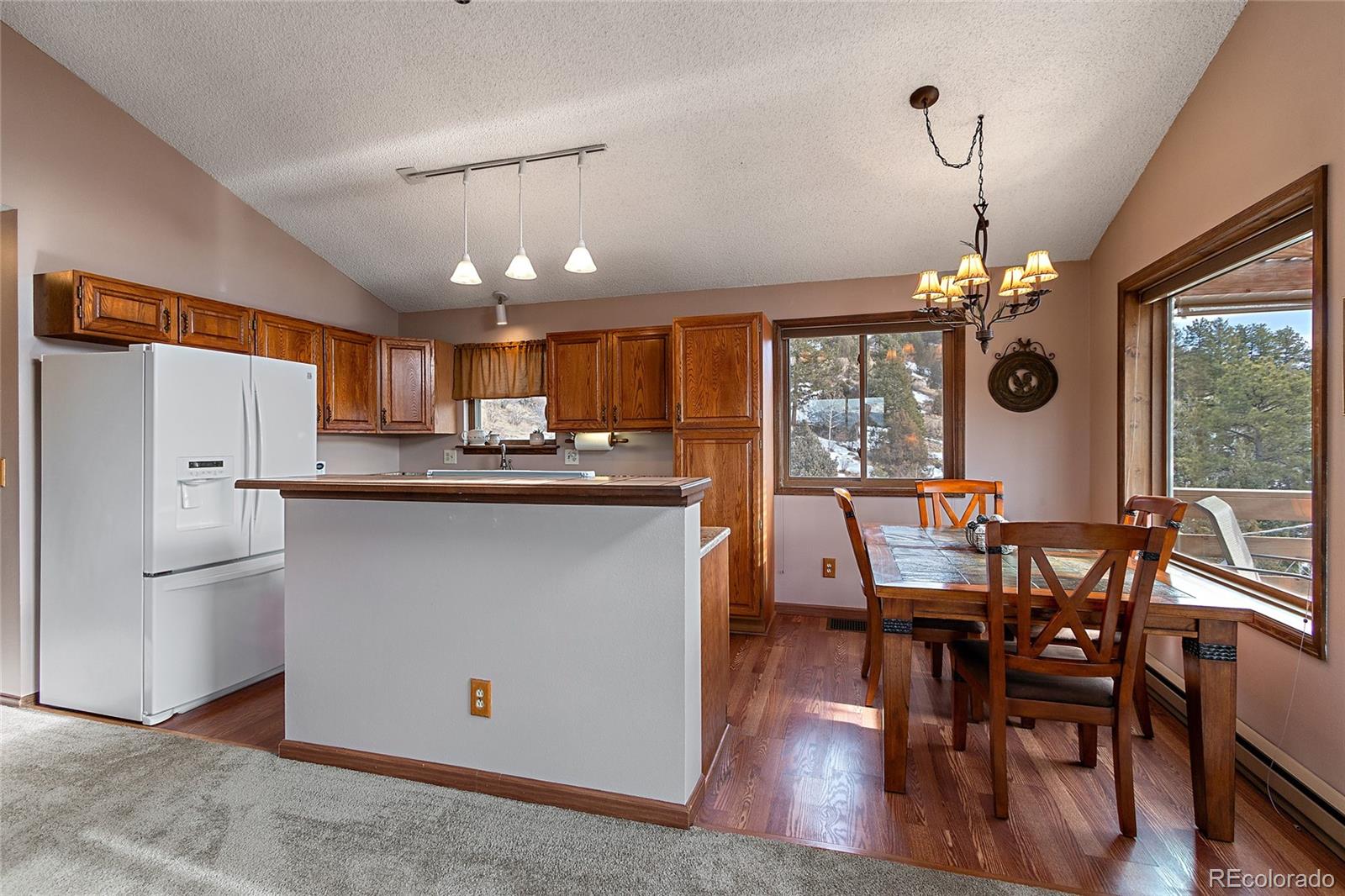 13976 Wamblee Trail Conifer, CO 80433 - Photo 13 of 39 a kitchen with stainless steel appliances granite countertop a stove refrigerator dining table and chairs