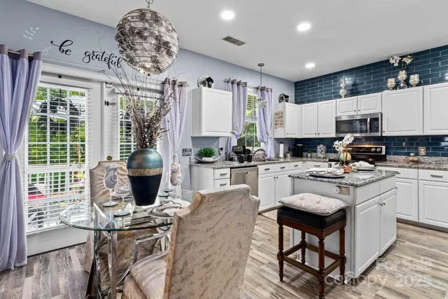 a kitchen with stainless steel appliances granite countertop a stove refrigerator sink and cabinets