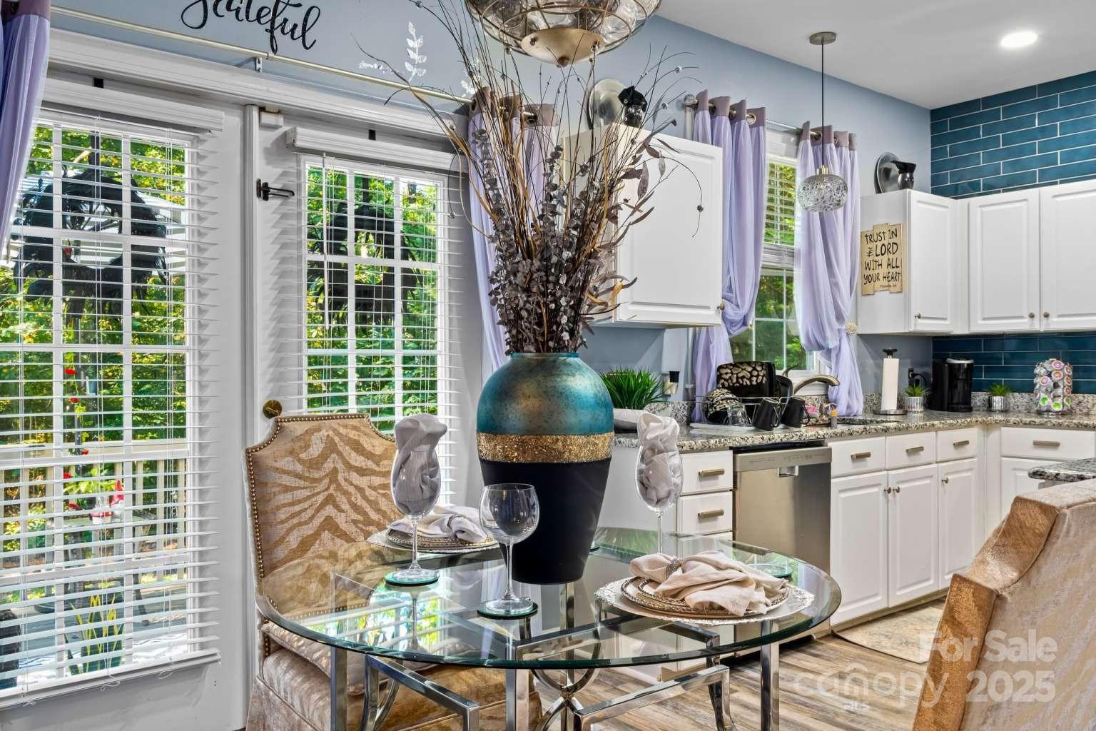 7828 Dunoon Lane Charlotte, NC 28269 - Photo 13 of 39 a kitchen with stainless steel appliances a table and chairs in it