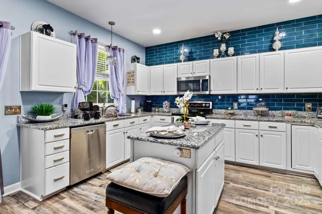 a kitchen with granite countertop a sink a stove and cabinets