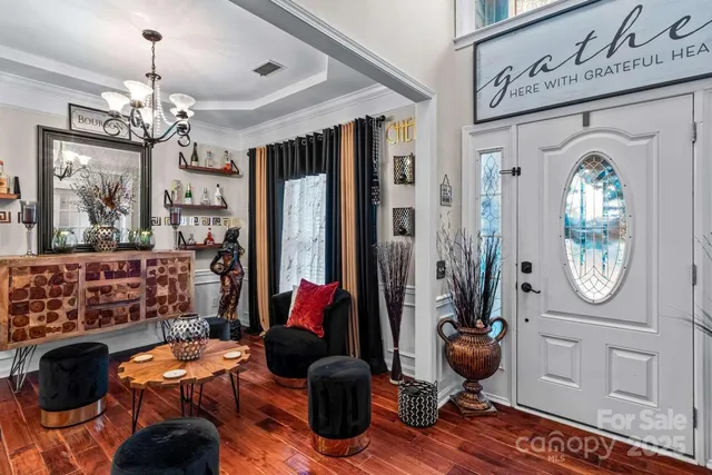 a living room with furniture a mirror and a chandelier