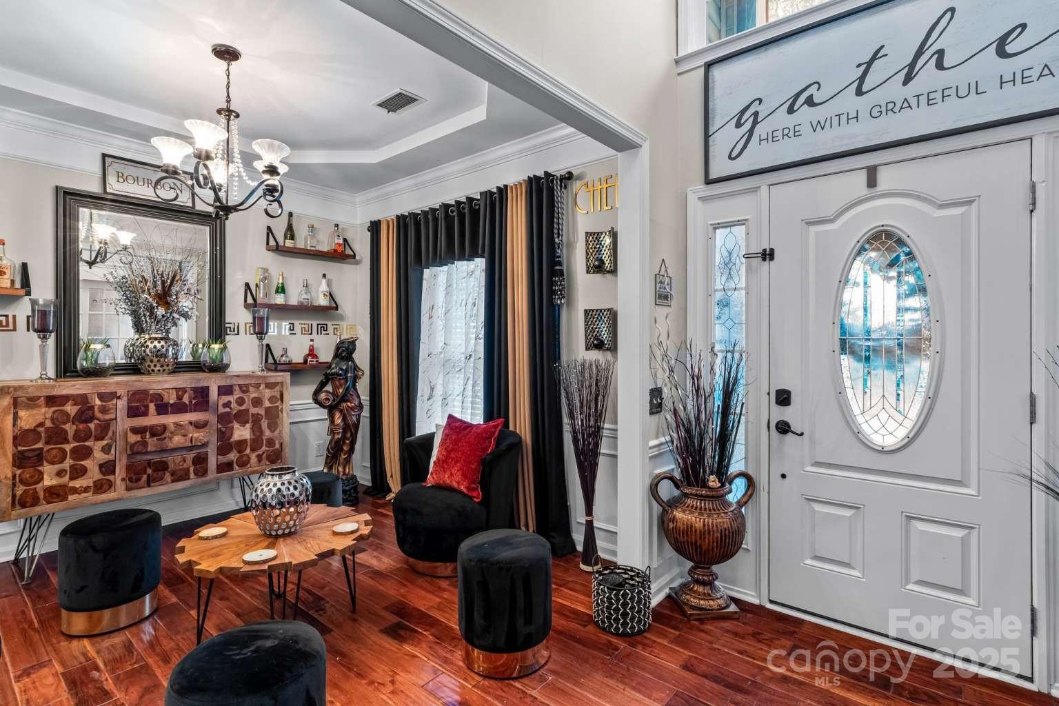 7828 Dunoon Lane Charlotte, NC 28269 - Photo 3 of 39 a living room with furniture a mirror and a chandelier