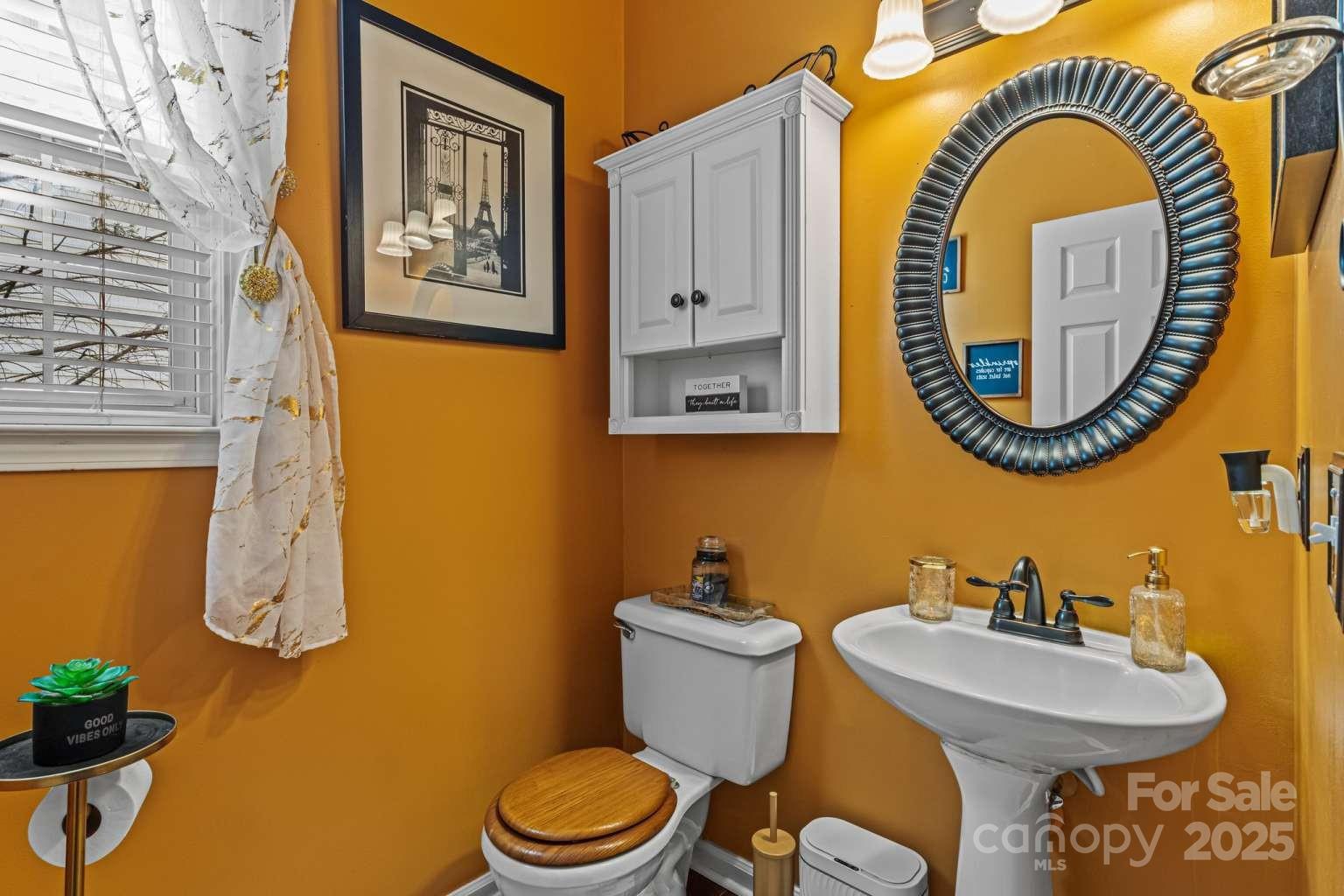 7828 Dunoon Lane Charlotte, NC 28269 - Photo 7 of 39 a bathroom with a toilet sink and mirror