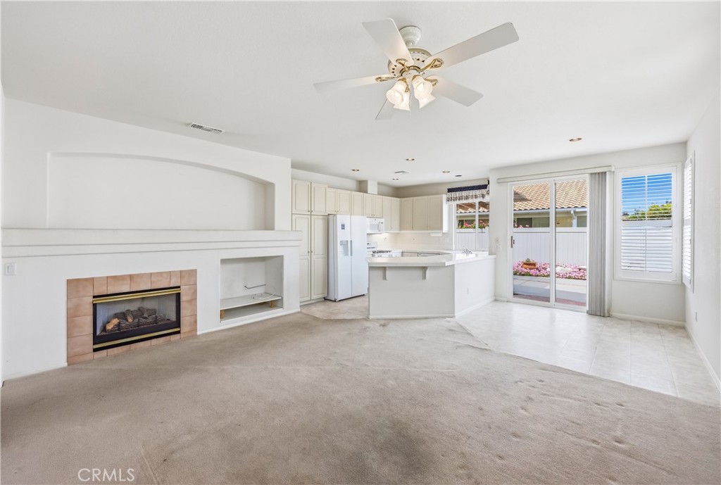1961 Riviera Avenue Banning, CA 92220 - Photo 27 of 60 a view of a livingroom with a fireplace a ceiling fan and windows