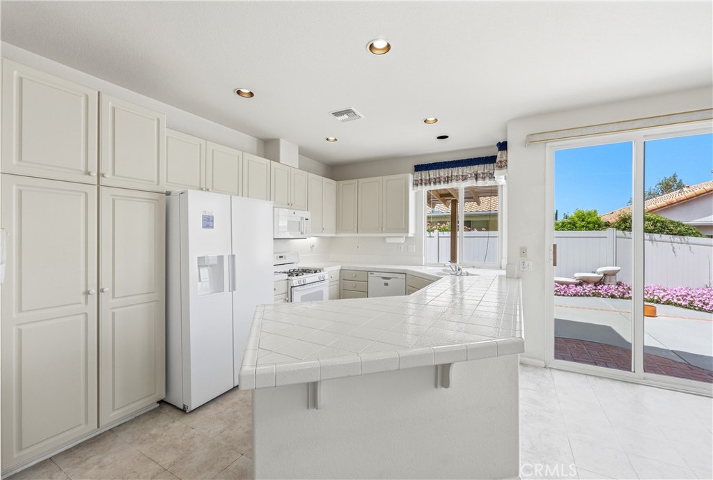 1961 Riviera Avenue Banning, CA 92220 - Photo 31 of 60 a kitchen with stainless steel appliances granite countertop a refrigerator a sink a stove and white cabinets