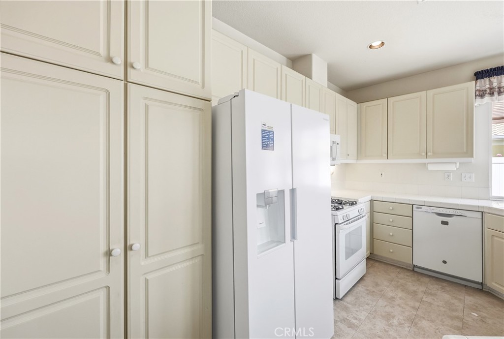 1961 Riviera Avenue Banning, CA 92220 - Photo 32 of 60 a kitchen with white cabinets and white appliances