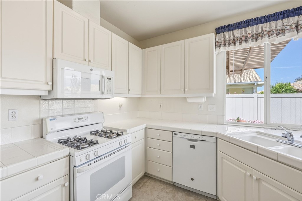 1961 Riviera Avenue Banning, CA 92220 - Photo 34 of 60 a kitchen with white cabinets and white appliances