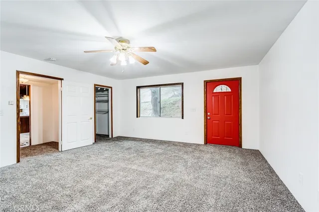 an empty room with windows and ceiling fan
