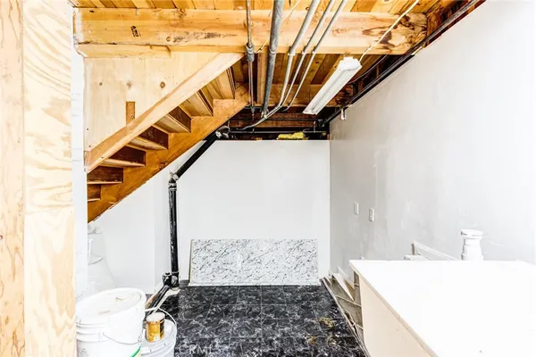 a bedroom with wooden floor and white walls