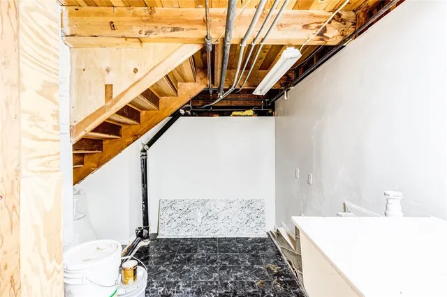 a bedroom with wooden floor and white walls