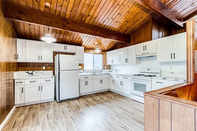 a kitchen with white cabinets and white appliances