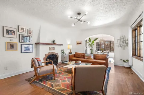 a living room with furniture a fireplace and wooden floor