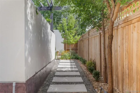 a view of a patio with table and chairs potted plants and large tree