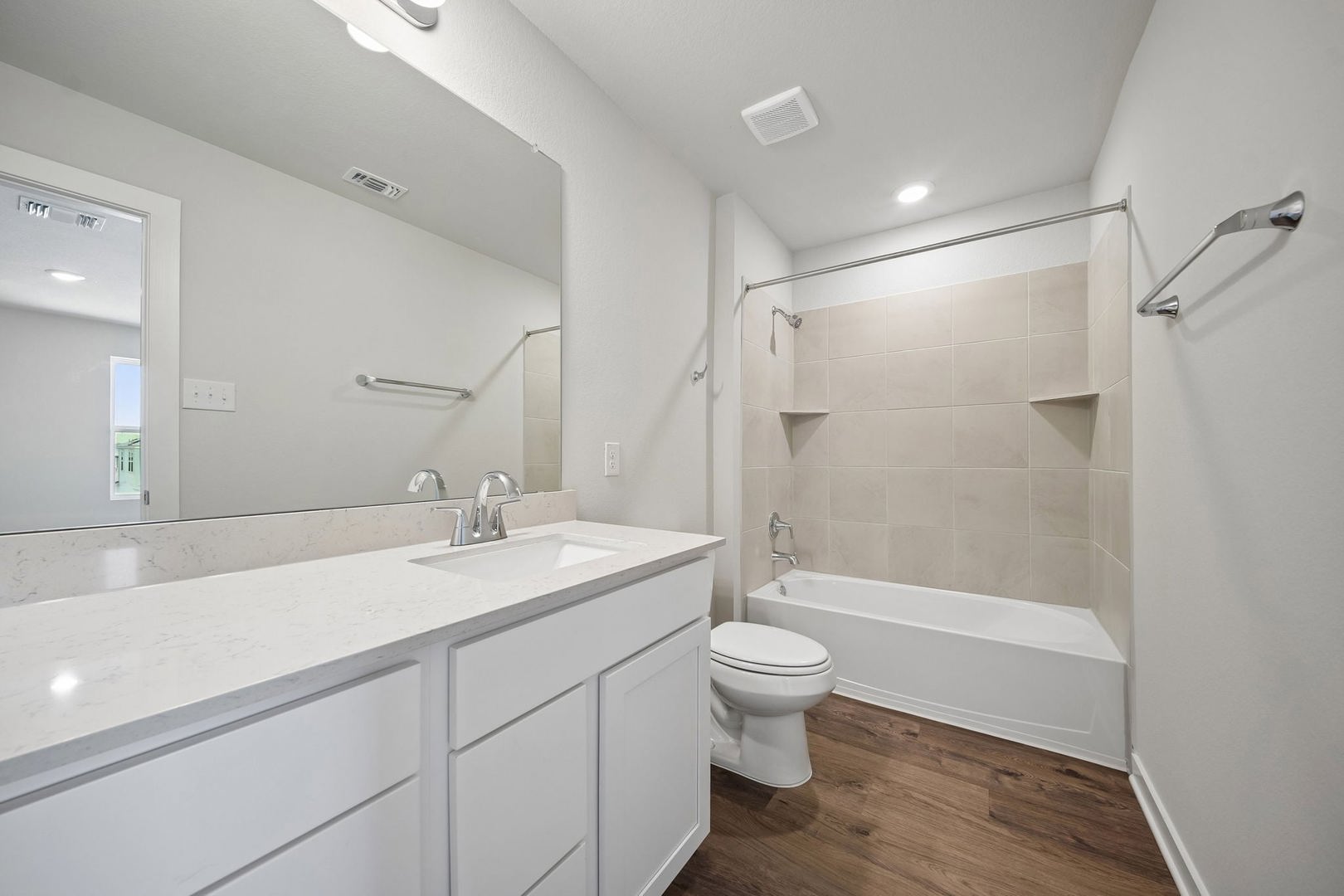145 Hornet Street Elgin, TX 78621 - Photo 2 of 18 A well-appointed bathroom features a spacious vanity with an integrated sink and a tiled shower-tub combination.