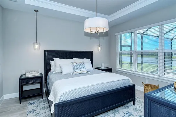 a bedroom with a large bed and a chandelier