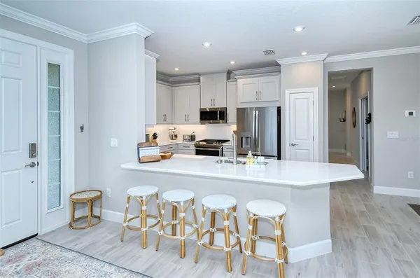 a large kitchen with stainless steel appliances kitchen island granite countertop a refrigerator and a stove top oven