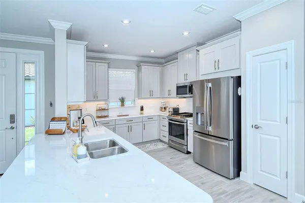a kitchen with white cabinets and stainless steel appliances