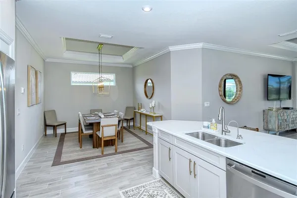 a living room with stainless steel appliances kitchen island granite countertop a dining table and chairs with wooden floor