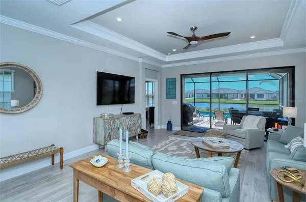 a living room with furniture tv and a floor to ceiling window