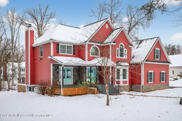 a view of a white house with large windows and a table and chairs