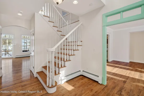 a kitchen with stainless steel appliances granite countertop a stove a sink and white cabinets with wooden floor