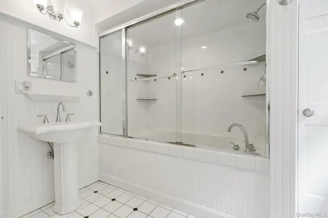 a bathroom with a shower sink and mirror