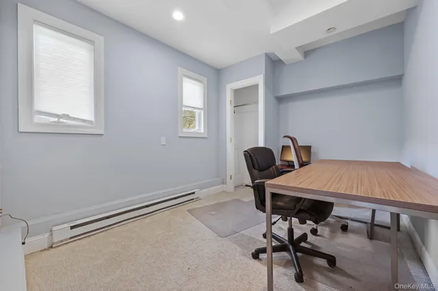 a view of a workspace with furniture and a window