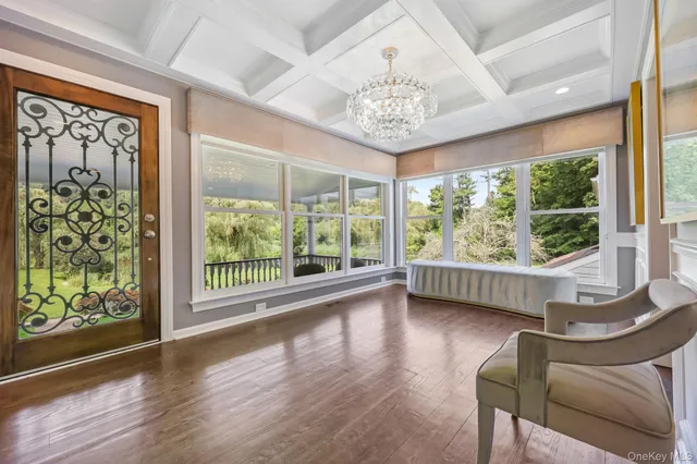 a view of a room with furniture large windows and wooden floor
