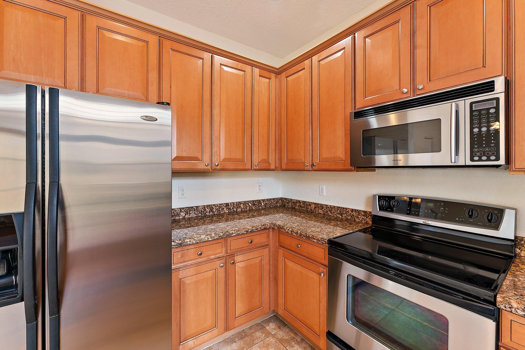 128 West Thatch Palm Circle Jupiter, FL 33458 - Photo 11 of 31 a kitchen with granite countertop cabinets stainless steel appliances and a counter space